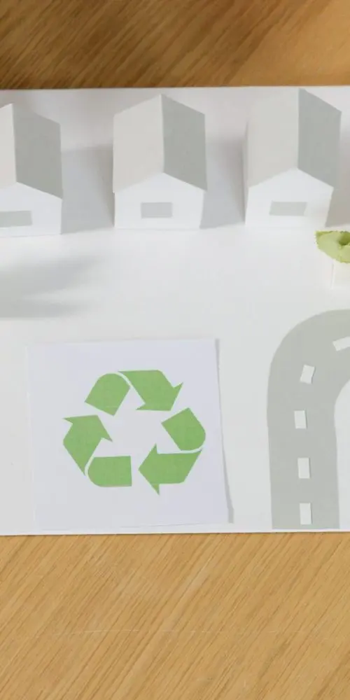 Image d'une feuille avec des maisons, arbres et logo recyclage